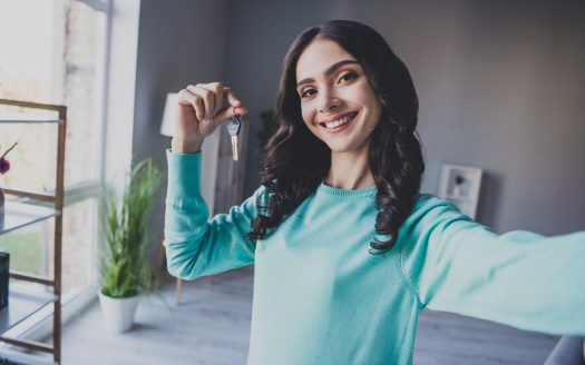 Ragazza giovane con in mano chiavi di una casa appena comprata