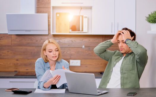 un uomo e una donna disperati davanti al computer, intenti a interpretare un documento complesso